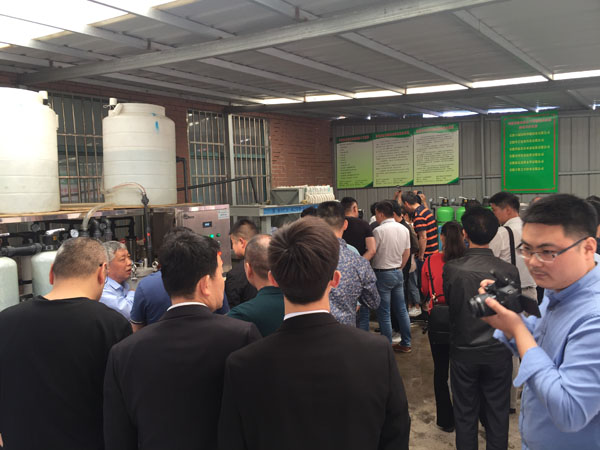 與會人員正在泰興廣力機械廠董事長徐貴山的介紹下，認真參觀新環保設備的運行情況