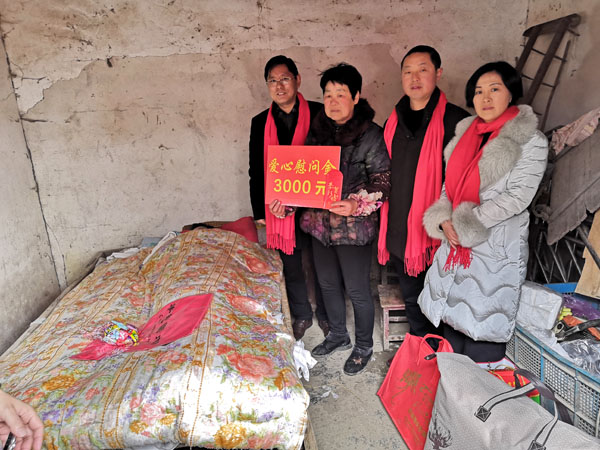 熊桂祥會長、徐敏秘書長給李金成特困老人送上慰問金和慰問物品，圖為他們和霍邱縣河口鎮領導、長年臥病在床的李金成（臥床者）及其照顧他的老姐姐（左二）合影留念